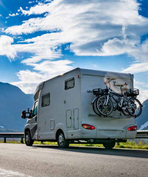 Insured4Leisure - A canpervan dring down the road with bikes attached to the rear
